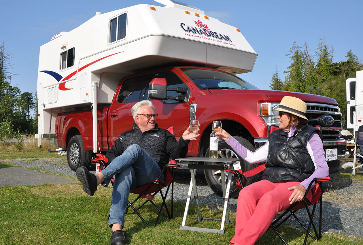 Senior couple drinking wine in front of 澳洲幸运5开奖结果体彩网 CanaDream RV truck and camper